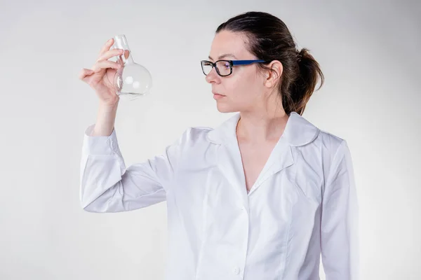 Asistent de laborator sau student de cercetare într-o haină albă. O tânără femeie doctor într-o haină albă de laborator — Fotografie, imagine de stoc