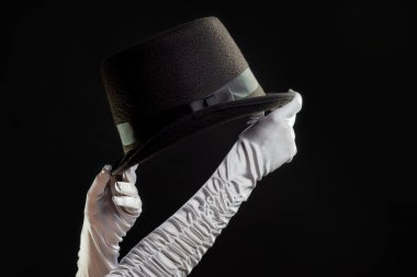 El hareketleriyle. İllüzyonist elinde bir şapka tutar ve sihir ve numaralar gösterir..