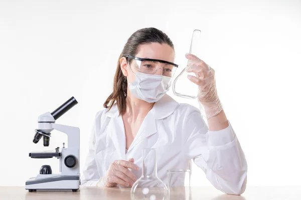 Asistente de laboratorio o estudiante de investigación con una bata blanca. Una joven doctora con una bata blanca de laboratorio —  Fotos de Stock