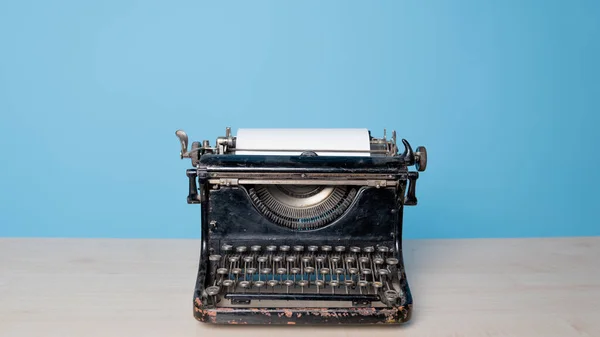 Retro vintage typemachine, vooraanzicht, blauwe achtergrond. — Stockfoto