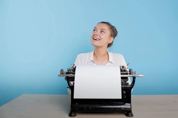 Feliz joven mujer es un autor en una máquina de escribir, se inspira, — Foto de Stock