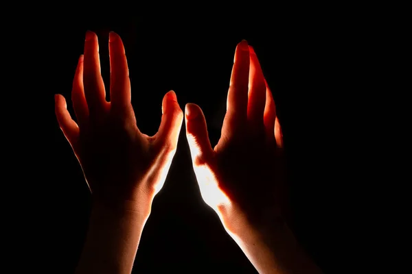 Magical reddish light shines from above on the palm of your hand. Hands reaching up, striving for high, concept. — Stock Photo, Image