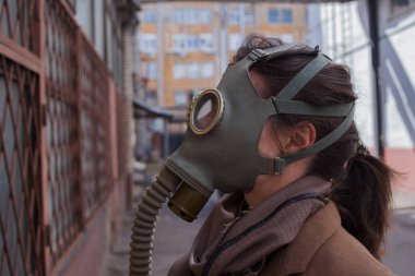Gaz maskesi, kitlesel enfeksiyonlar ve çevresel sorunlar içinde kasvetli bir sokakta yürüyen bir kadın..