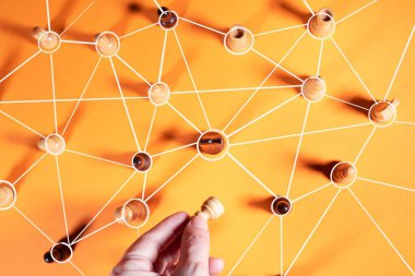 Yakın bir ekibin yeni bir çalışanı, bir konsept. Satranç taşları turuncu arkaplandaki çizgilerle birbirine bağlıdır.,