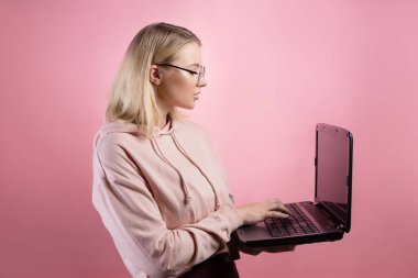 Genç bir kadın, öğrenci ya da serbest çalışan, çalışmak ya da çalışmak için dizüstü bilgisayar kullanır..