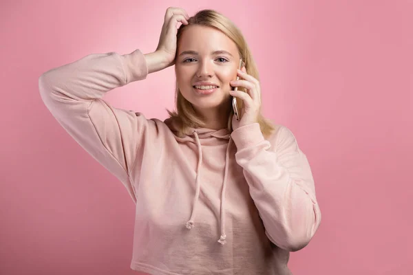 Una giovane donna bionda con un taglio di capelli quadrato, emotivamente parlando al telefono — Foto Stock