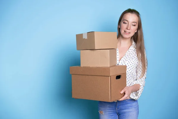 Accept a parcel, happy young woman holding a stack of cardboard boxes,