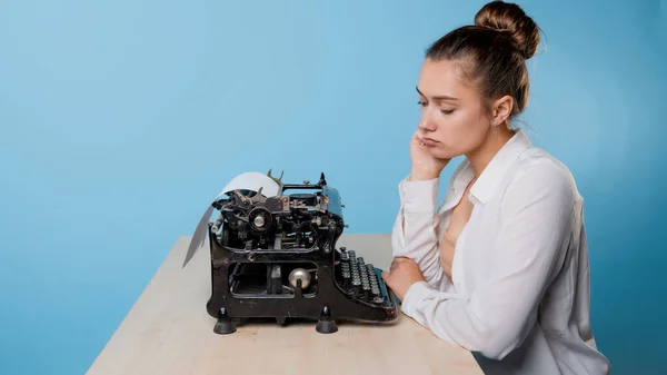 Jeune femme écrivain s'ennuie à une machine à écrire, procrastination et syndrome de l'imposteur. — Photo