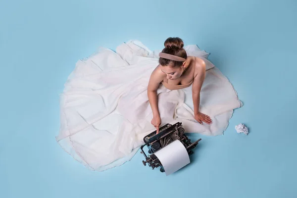 Jong romantisch vrouw is een auteur op een typemachine, zitten op de vloer in een pluizig wit rokje — Stockfoto