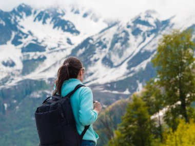 Sırtında sırt çantasıyla dağlarda yürüyüş yapan genç bir turist.,