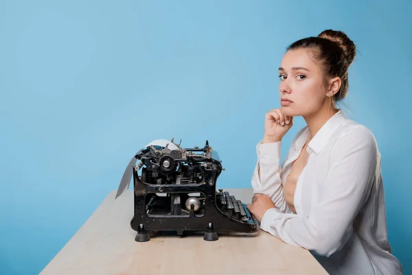 Joven escritora se aburre de una máquina de escribir, la dilación y el síndrome de impostor. — Foto de Stock