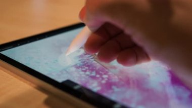 Grafik tablet üzerine çizim yapan sanatçının eli soyut bir desen çizer.