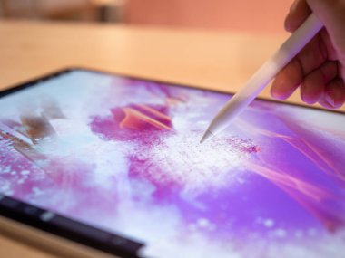 Grafik tablet üzerine çizim yapan sanatçının eli soyut bir desen çizer.