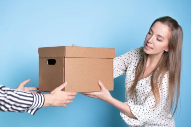 Bir kutuyu elden ele gönderiyorsun, transfer ediyorsun ve kabul ediyorsun. Genç bir kadın bir hediye ya da teslimat alıyor..