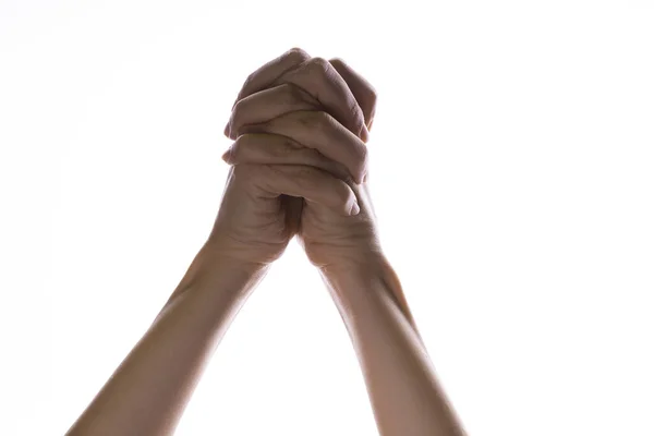 Rezando mãos cruzadas sobre um fundo branco. Luz de cima. Mãos dobradas em oração. — Fotografia de Stock