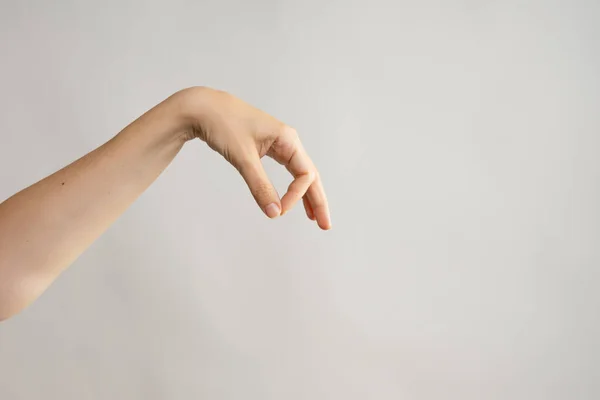 Gestos de mão. Elegante mão feminina segurando algo com dois dedos — Fotografia de Stock