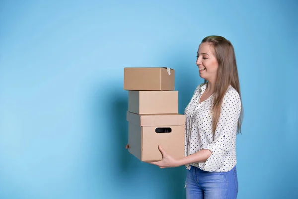 Accept a parcel, happy young woman holding a stack of cardboard boxes,