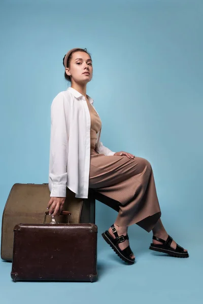 Fiatal nő nyári nadrág és egy fehér ing ül a vintage bőr bőröndök — Stock Fotó