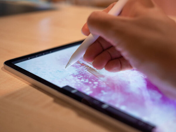 Drawing on a graphic tablet, the artists hand draws an abstract pattern