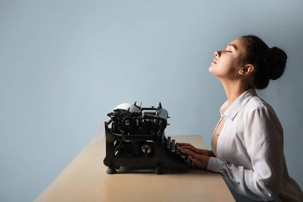 Feliz joven mujer es un autor en una máquina de escribir, se inspira, — Foto de Stock