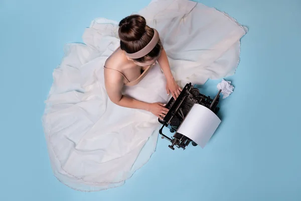 Jong romantisch vrouw is een auteur op een typemachine, zitten op de vloer in een pluizig wit rokje — Stockfoto