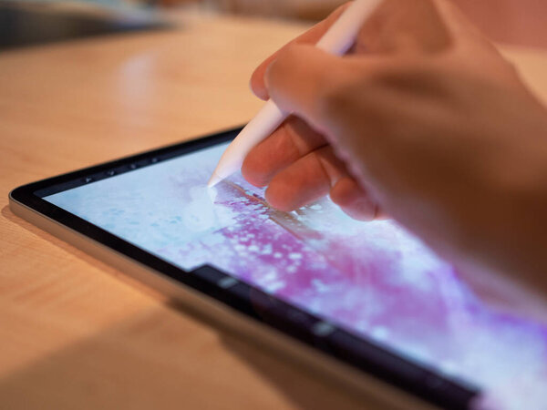 Drawing on a graphic tablet, the artists hand draws an abstract pattern