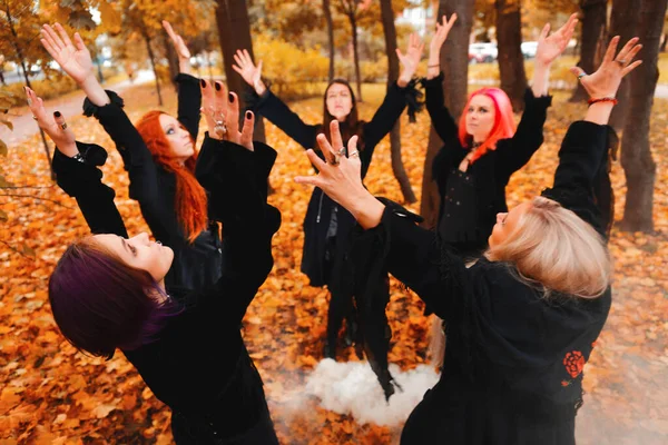 Coven of witches, un groupe d'amis en tant que sorcières à Halloween effectuer un rituel, mener une danse ronde et réciter des sorts. — Photo