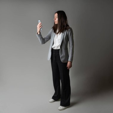 Ceket ve pantolon giymiş sıradan bir iş kadını.