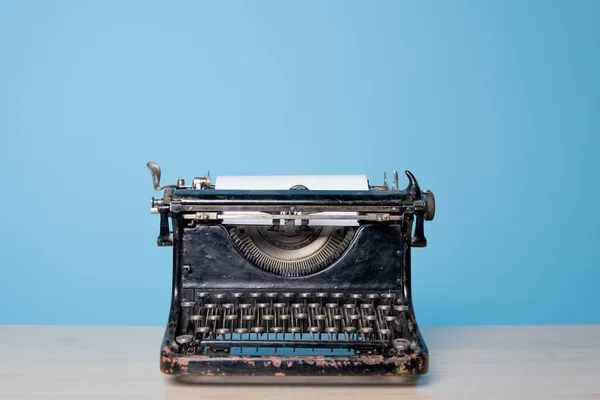 Retro vintage typemachine, vooraanzicht, blauwe achtergrond. — Stockfoto