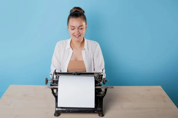 Feliz joven mujer es un autor en una máquina de escribir, se inspira, — Foto de Stock