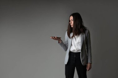 Ceket ve pantolon giymiş sıradan bir iş kadını.