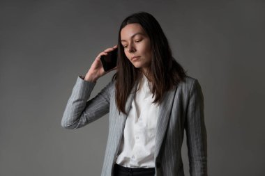 Ceket ve pantolon giymiş sıradan bir iş kadını.