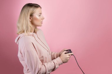 Oyuna tutkulu genç sarışın bir kız oyun sahası kullanıyor.