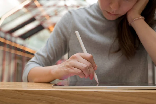 Een digitale kunstenaar maakt gebruik van een grafische tablet met behulp van een stylus, een freelancer werkt in een publieke ruimte coworking — Stockfoto