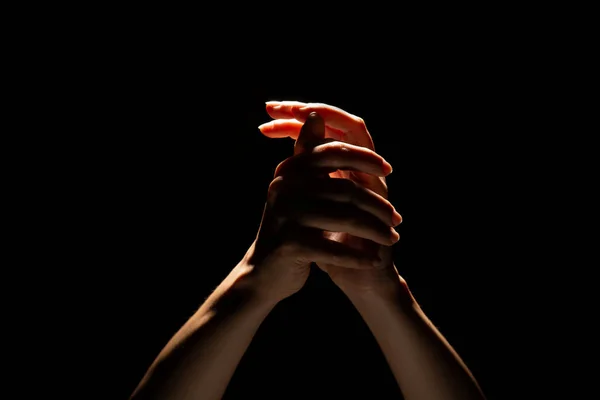 Praying hands on a black background. Light from above. Hands folded in prayer. — Stock Photo, Image