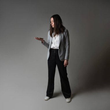 Ceket ve pantolon giymiş sıradan bir iş kadını.