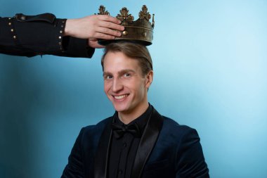 VIP insan kulübü, davetiye. Zengin takım elbiseli genç bir adam tacı alır.