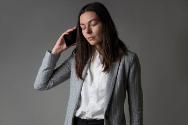 Ceket ve pantolon giymiş sıradan bir iş kadını.