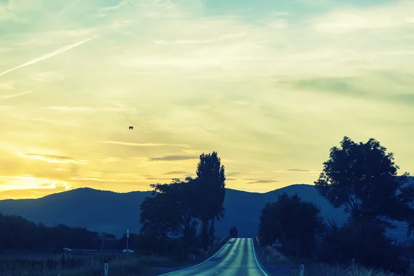 Na estrada na hora do pôr do sol — Fotografia de Stock