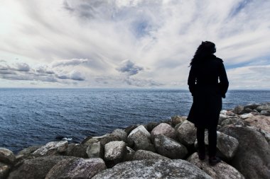 Deniz günbatımı, dramatik görünüm, kadın kenarında, kadın siluet alışılmadık, yabancı kavramı üzerinde izlerken kayaların üzerinde duran kadın