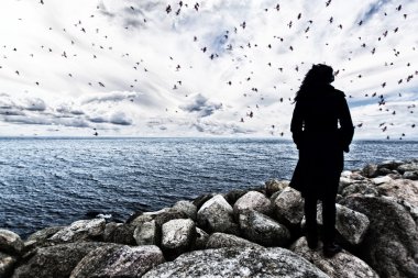 Deniz günbatımı, dramatik görünüm, kadın kenarında, kadın siluet alışılmadık, yabancı kavramı üzerinde izlerken kayaların üzerinde duran kadın