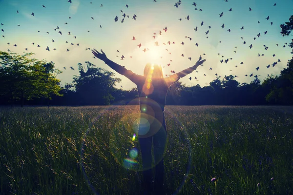 Ung flicka sprider händer med glädje och inspiration inför solen, solen hälsningen, frihet koncept, fågel flyger över tecken av frihet och frihet — Stockfoto
