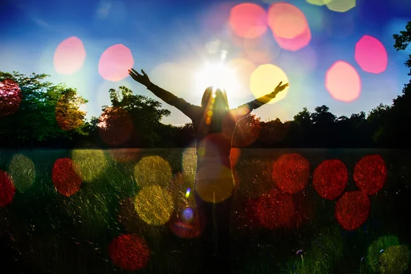 Jovem estendendo as mãos com alegria e inspiração de frente para o sol, saudação ao sol, conceito de liberdade, pássaro voando acima do sinal de liberdade e liberdade — Fotografia de Stock