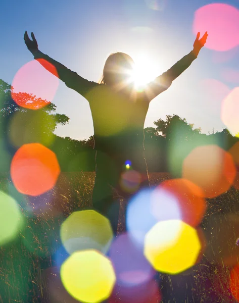 Jovem estendendo as mãos com alegria e inspiração de frente para o sol, saudação ao sol, conceito de liberdade, pássaro voando acima do sinal de liberdade e liberdade — Fotografia de Stock