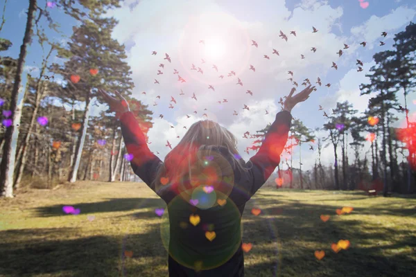 Jovem estendendo as mãos com alegria e inspiração de frente para o sol, saudação ao sol, conceito de liberdade, pássaro voando acima do sinal de liberdade e liberdade — Fotografia de Stock