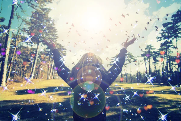 Chica joven extendiendo las manos con alegría e inspiración frente al sol, saludo al sol, concepto de libertad, pájaro volando por encima de signo de libertad y libertad — Foto de Stock