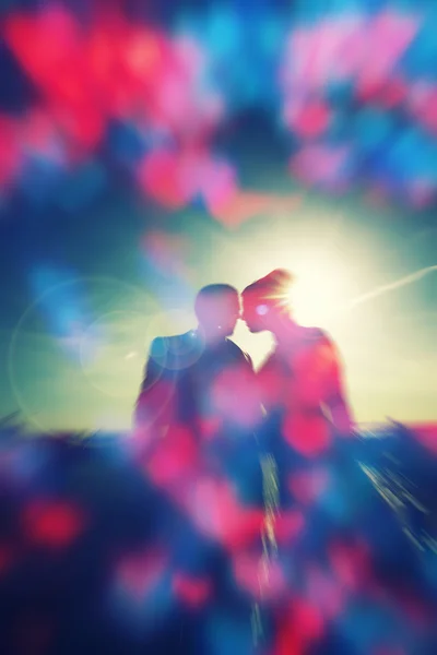 Casal silhueta sobre o pôr do sol, fundo bokeh coração, emoções e conceito de amor, felicidade — Fotografia de Stock