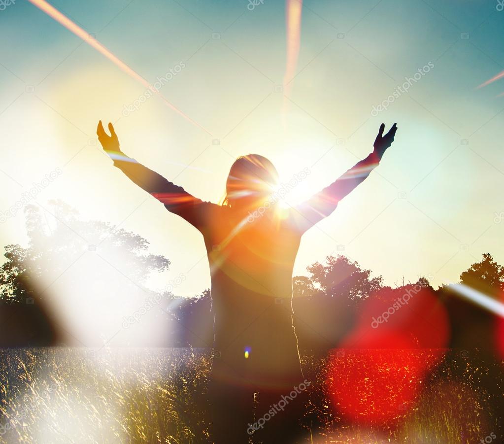 Young girl spreading hands with joy and inspiration facing the sun,woman and freedom
