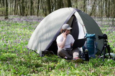 Açık havada çalışan bir çadır kampında adam fotoğrafçı.