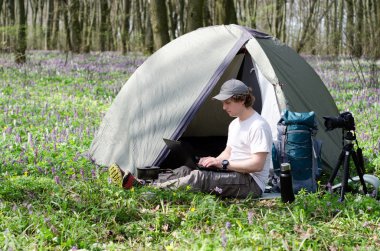 Açık havada çalışan bir çadır kampında adam fotoğrafçı.
